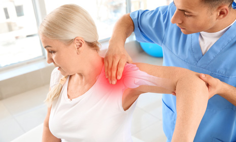 Therapist assisting patient with shoulder pain